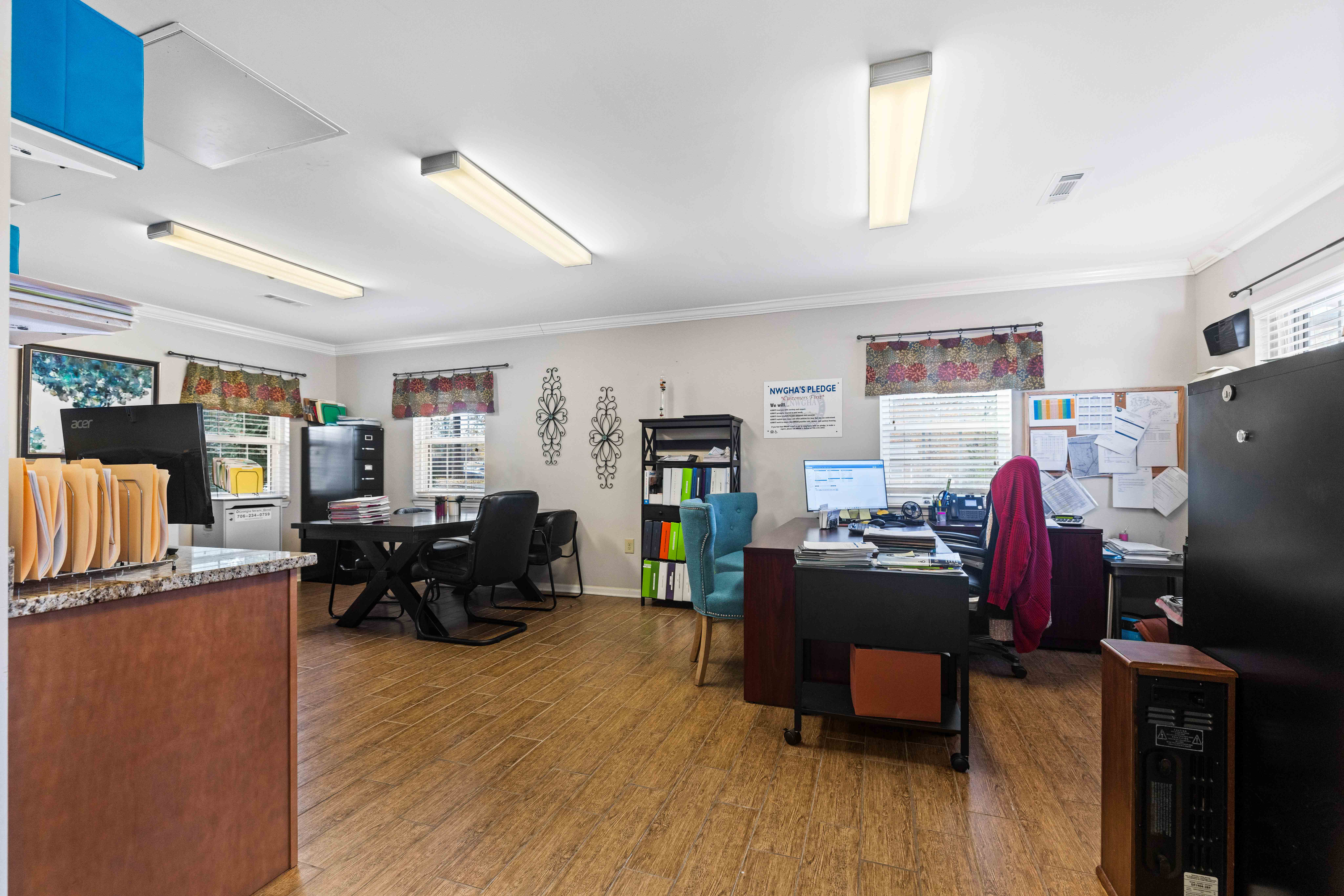 A room with a desk, chairs, and computers.